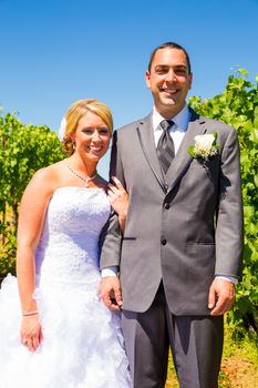 A bride and groom pose for portraits on their wedding day at a winery vineyard outdoors in oregon.