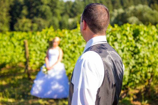 A shallow depth of field is used on this shallow focus layered shot of a bride and groom on their wedding day at a vineyard winery in Portland Oregon.