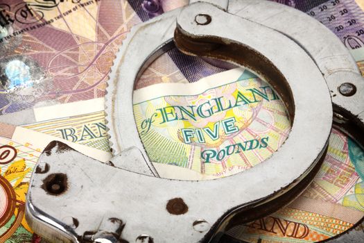 handcuffs and British money close up 