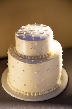 A wedding cake is ready to be cut at a reception on the bride and groom wedding day.