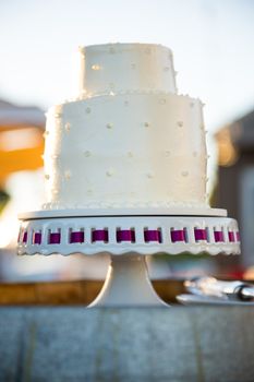 A wedding cake is ready to be cut at a reception on the bride and groom wedding day.