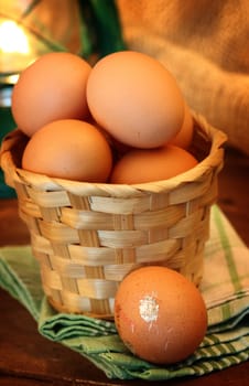 Fresh eggs in basket on wooden table 