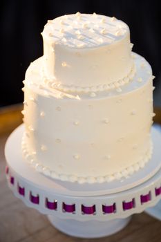 A wedding cake is ready to be cut at a reception on the bride and groom wedding day.