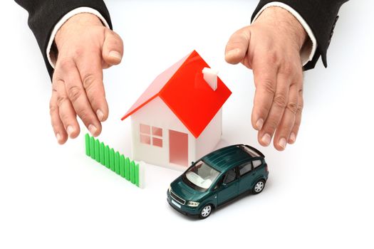 Hands, car and house model. Real property or insurance concept 