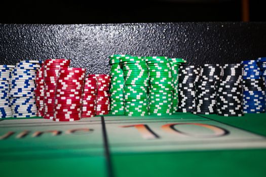 These tokens are stacked up high in a big stack at a craps table for a gambling themed wedding reception.