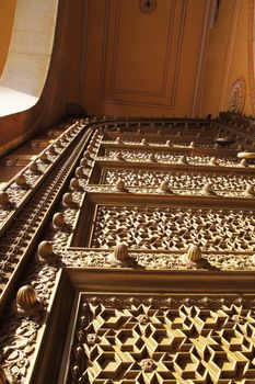 Intricately carved tall metal gate at a palace in Jaipur, Rajastan