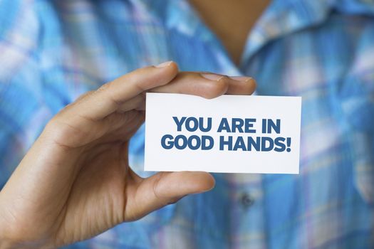 A person holding a white card with the words You are in Good hands