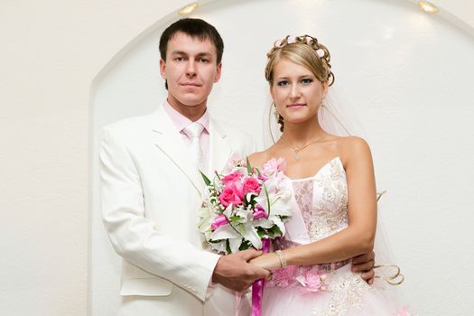 The bride in a pink dress and the groom in white suit