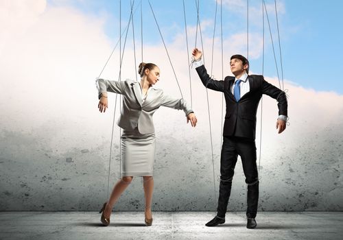 Image of businesspeople hanging on strings like marionettes. Conceptual photography