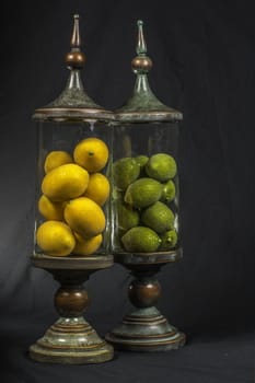 Decorative vintage glass jars filled with limes and lemons.