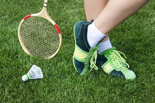 foot of woman who plays badminton on grass