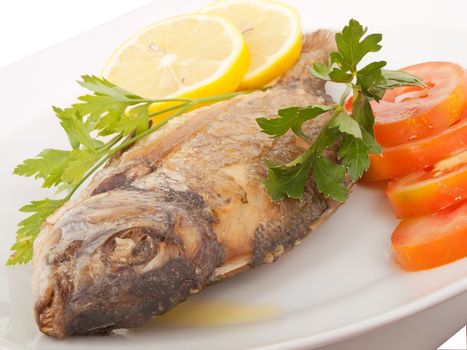 diplodus puntazzo, delicious grilled fish with sliced tomato, lemon and parsley; all in olive oil  