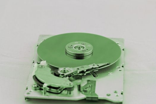 Open computer hard drive on white background with green (HDD, Winchester)