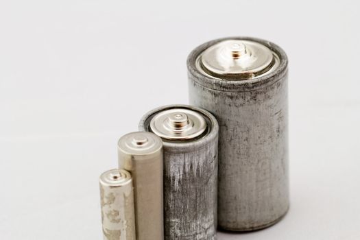 Old grey batteries on white background (aa, aaa, b, c)