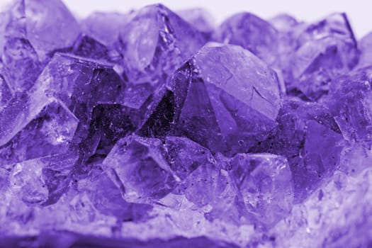 Close up picture about a crystal with purple color on white background
