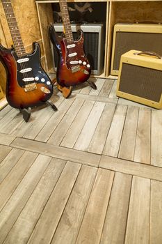 Two electric guitar with amplifiers display around them. 