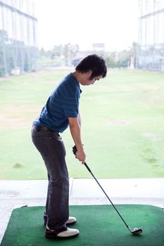 Young male golfer practicing his drive