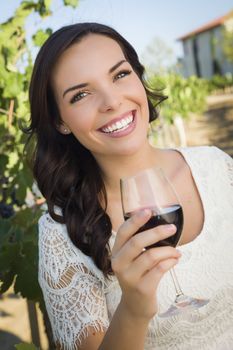 Pretty Mixed Race Young Adult Woman Enjoying A Glass of Wine in the Vineyard.