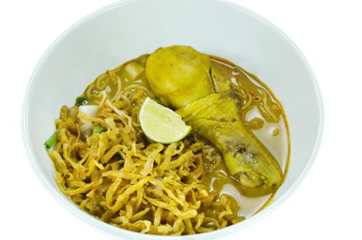 A noodle dish in a yellow curry with chicken  on white background