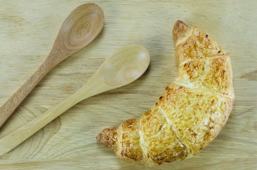 top view of croissants with spoon   on wooden  background