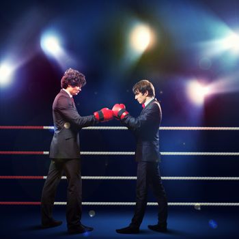 Two young businessman boxing againts dark background . conceptual collage