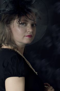 Elegant retro woman in veil over dark background