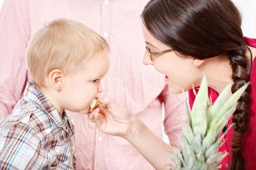 Mother feeding child with apple