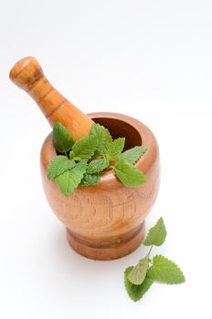 wooden mortar with melissa leaves