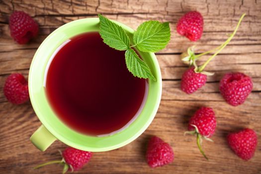 Raspberry tea with berry fruit on wooden table background. Top view