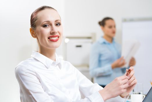 portrait of a business woman in office, smiling and looking into the camera, office work