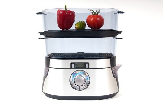 modern electric steamer with fresh vegetables on a white background 