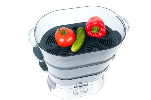 modern electric steamer with fresh vegetables on a white background 