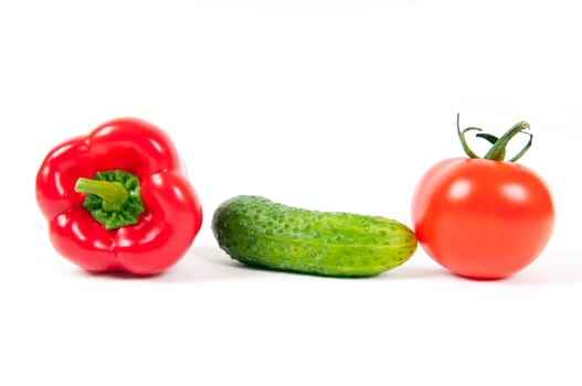 red pepper, tomato and green cucumber isolated on a white background