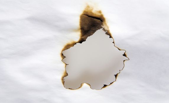 hole in the paper scorched by fire