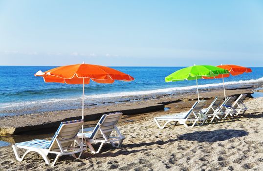 parasols and deck chairs on a sandy beach