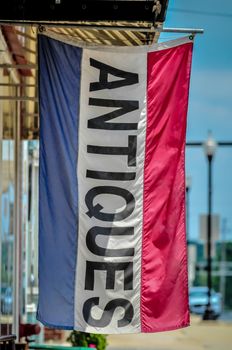 antiques flag sign for an antique shop on city street