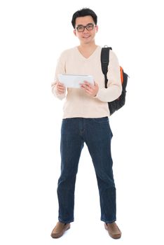 Full body Asian adult student in casual wear  using digital computer tablet pc standing isolated on white background. Asian male model.