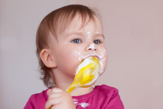 Child girl eating with spoon enjoying her favourite food