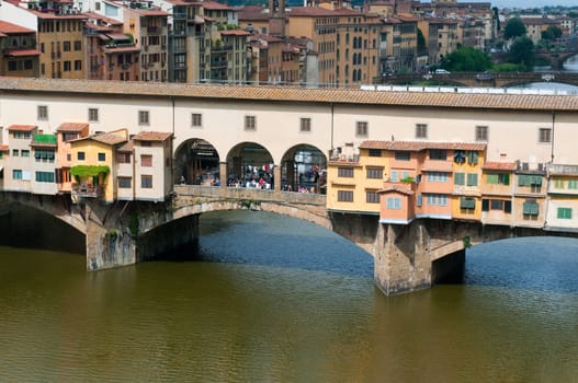 Crowds of tourists visit the Ponte Vecchio ("Old Bridge") which is a Medieval bridge over the Arno River in Florence, Tuscany, Italy.