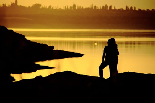 romantic couple watching sunset while standing