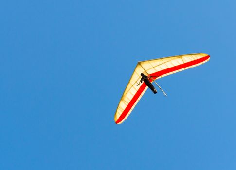 Hang Glider flying in clear blue sky