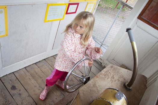 A preschool aged girl inside a wooden ship at Norrkvarn, Göta kanal, sweden, Candid shot real people