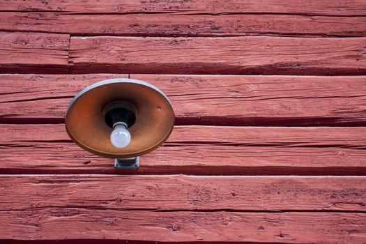 A lamp from early last century on a red barn in Sweden