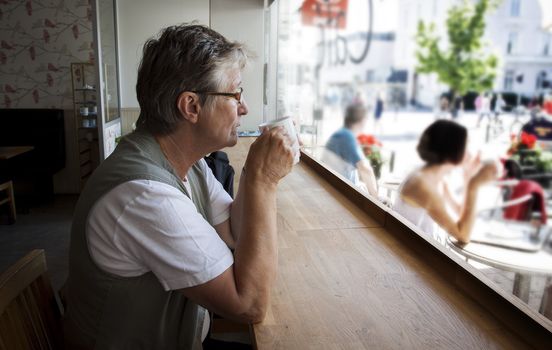 Senior pensioner having a coffee in a coffee shop in Sweden