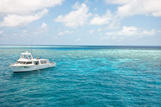 Dive boat stationed off the Great Barrier Reef in Queensland, Australia in a calm blue ocean