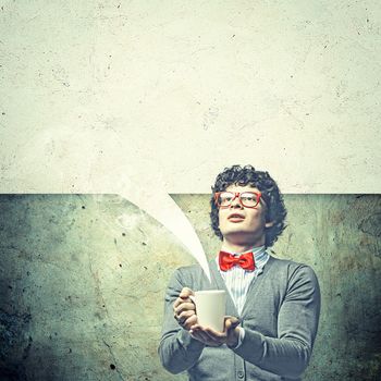 Young man with blank frames against a grey wall