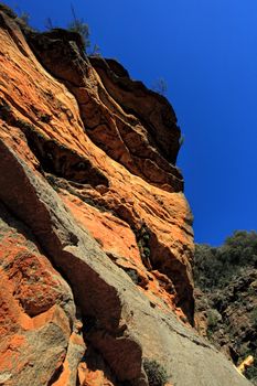 Iconic Australian landscape of magnificent red rock cliffs along the National Pass against a deep blue aky -  These beautiul natural wonder is world heritage listed and UNESCO awarded.  The National Pass features various red, pink and white cliffs along its steep descent.