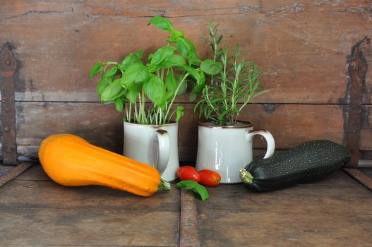 Rustic kitchen with herbs, tomatoes and squash