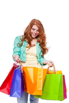 smiling young redhead girl with colorful shoppingbags  isolated on white background