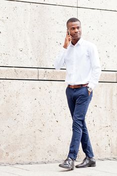 young successfil african businessman with mobilephone talking walking outdoor